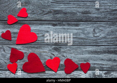 Valentines Day. Cœurs à la main sur bois tranche sur fond de bois gris vintage rustique. Valentine's Day love concept. Happy feelin Banque D'Images