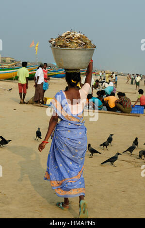 Femme avec un crabe plat sur la tête sur une plage en Orissa, Inde Banque D'Images