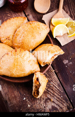 Boulangerie maison empanadas végétarien, légumes farcis de style latino-américain pie avec compotée de choux, carottes, oignons, tomates sur l'arrière en bois rustique Banque D'Images