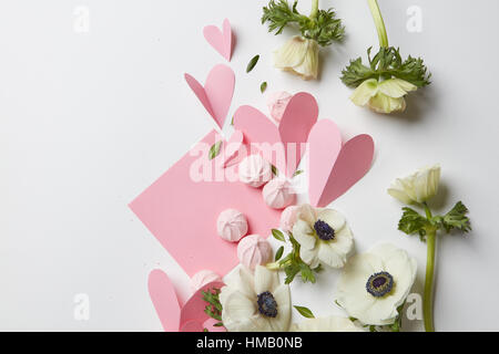 Valentines Day ou maquette de mariage scène avec carte vierge, papier coeurs, Fleurs et meringue sur un fond blanc, l'espace vide pour votre texte, Banque D'Images