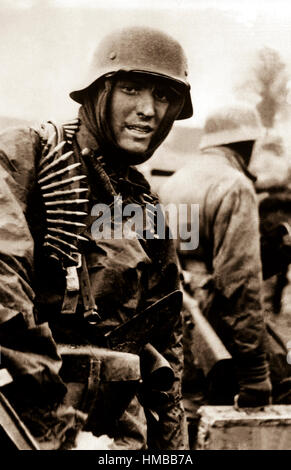 Un soldat nazi, lourdement armés, transporte des caisses de munitions de l'avant avec compagnon en territoire prises par leur contre-offensive dans cette scène du film allemands capturés. Belgique, décembre 1944. (Armée) Date exacte inconnue Shot #  FICHIER NARA : 111-SC-197561 LIVRE Guerres et conflits #  : 1070 Banque D'Images