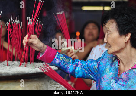 Jakarta, Indonésie - le 29 janvier 2017 : Chinese elder brûler l'encens dans la célébration du Nouvel An lunaire chinois au temple de Jin Yuan, Jakarta, Indonésie Banque D'Images