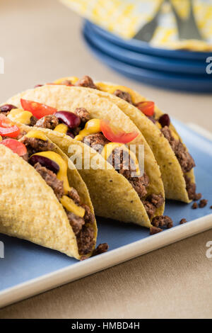 Tacos mexicains avec le boeuf, le fromage cheddar, tomates, haricots et trempettes salsa Banque D'Images