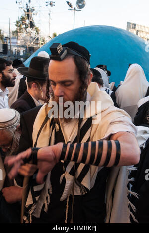 MERON, ISRAËL - 18 MAI 2014 : Un Juif orthodoxe de mettre sur ses tefillin, près de la tombe de Rabbi Shimon, lors de l'Assemblée hillulah de Rabbi Shimon Bar Yocha Banque D'Images