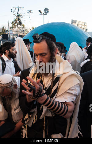 MERON, ISRAËL - 18 MAI 2014 : Un Juif orthodoxe de mettre sur ses tefillin, près de la tombe de Rabbi Shimon, lors de l'Assemblée hillulah de Rabbi Shimon Bar Yocha Banque D'Images