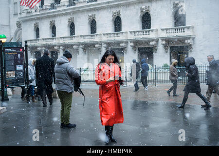 Les travailleurs du centre-ville et les touristes intrépides braver le froid et la neige en face de la Bourse de New York le mardi 31 janvier, 2017. La neige se détendre par la fin de l'après-midi ne laissant qu'environ un pouce dans la ville. (© Richard B. Levine) Banque D'Images