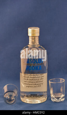 KIEV, UKRAINE - le 30 avril 2012 : bouteille de vodka Absolut blue label et verres vides contre le bleu. Absolut est une marque de la vodka produite en Suède Banque D'Images