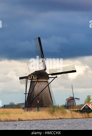 Les moulins à vent contre ciel nuageux au coucher du soleil à Kinderdijk, célèbre aux Pays-Bas. Paysage rustique avec moulins à vent traditionnel néerlandais Banque D'Images