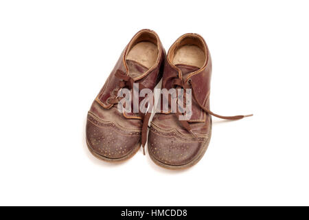 Une paire de richelieus marron vintage et éraflée, Oxford ou Wingtip chaussures pour enfant isolé sur blanc. Banque D'Images