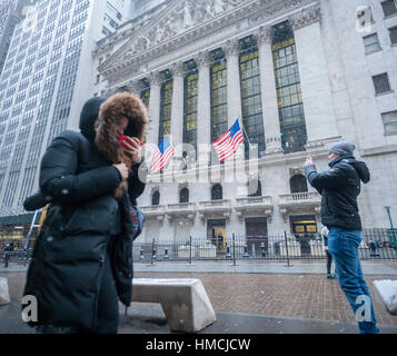 Les travailleurs du centre-ville et les touristes intrépides braver le froid et la neige en face de la Bourse de New York le mardi 31 janvier, 2017. La neige se détendre par la fin de l'après-midi ne laissant qu'environ un pouce dans la ville. (© Richard B. Levine) Banque D'Images