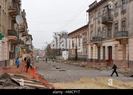 LVIV, UKRAINE - le 13 novembre : Les piétons marcher le long de la rue Zamarstynivska (noms d'anciens ponts de pierre, Kalinina) pendant la réparation de la rue énorme travaille sur Banque D'Images