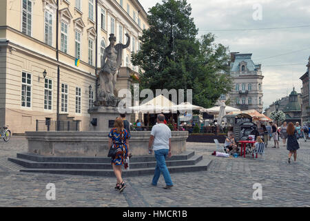 LVIV, UKRAINE - le 29 juillet 2014 : les piétons à pied en face de l'ancienne statue d'Amphitrite (marché sur la place Rynok), la place centrale et les plus populaires Banque D'Images