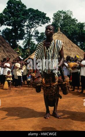 Un homme Yacouba à jouer de la batterie, et l'exécution d'une danse dans le village de Silacoro, sur les pentes du mont Zala, région de l'homme, Banque D'Images