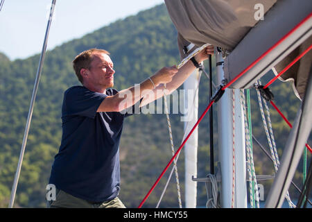 Skipper se resserre les cordes sur son yacht. Banque D'Images