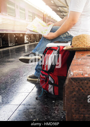 Voyageur asiatique homme avec effets personnels en attente de voyager par train à la gare de Chiang Mai, Thaïlande. Banque D'Images