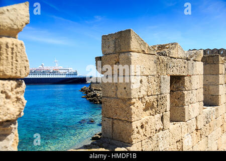 Bateau de croisière amarré dans la ville de Rhodes, Rhodes, Grèce, vue à travers les murs de la vieille ville Banque D'Images