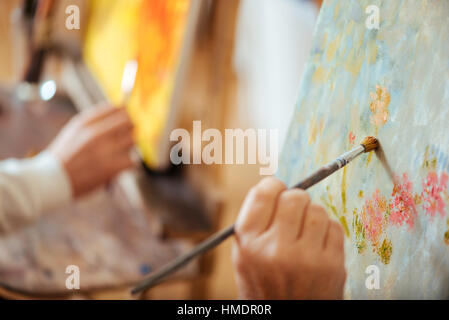 Close up de deux artistes mains peinture photos avec des brosses Banque D'Images
