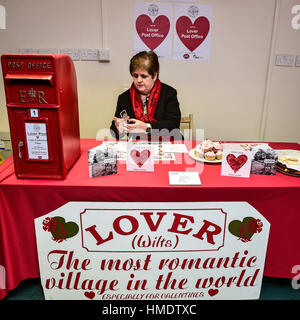 Maîtresse en Chef Lynda Cooper stamps Valentines cartes dans le bureau de poste dans le village de Lover, New Forest, où les résidents ont lancé une Saint-valentin post service, permettant aux romantiques dans le monde d'envoyer une carte du village du Wiltshire. Banque D'Images