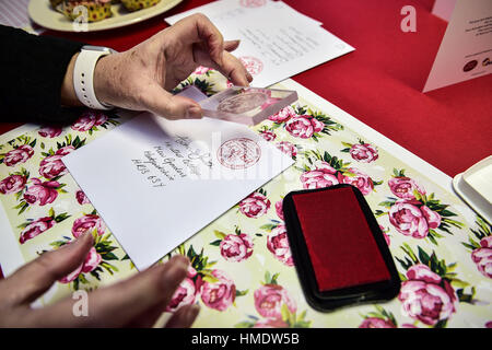 Maîtresse en Chef Lynda Cooper stamps une maquette de carte de Saint-valentin dans le bureau de poste dans le village de Lover, New Forest, où les résidents ont lancé une Saint-valentin post service, permettant aux romantiques dans le monde d'envoyer une carte du village du Wiltshire. Banque D'Images