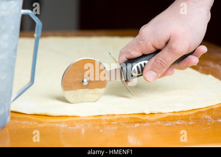 Pâte de coupe homme avec un couteau à rouleaux Banque D'Images