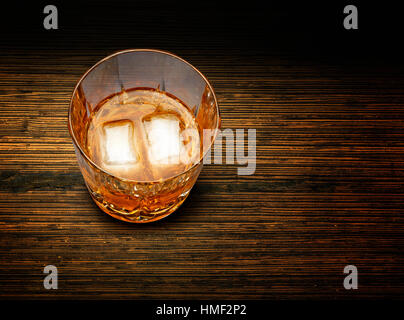 Parfait verre de whisky et de glace sur fond de bois texturé Banque D'Images