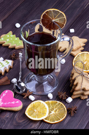 Vin chaud de Noël dans un verre avec des oranges séchées biscuits de Noël de l'anis étoilé la cannelle sur fond de bois foncé Banque D'Images