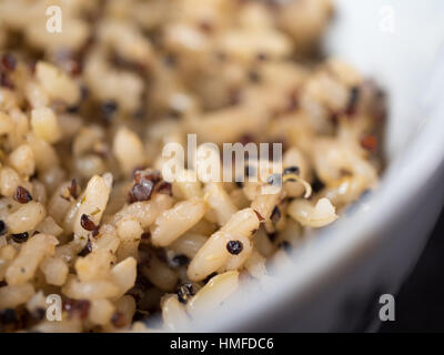 Un bol de quinoa biologique et de farine de riz dans une cuisine, sur un plan de travail en granit noir Banque D'Images