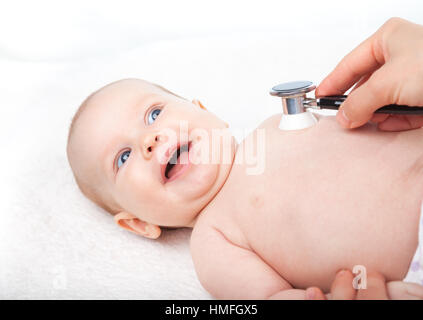 Le pédiatre examine trois mois bébé fille. Médecin à l'aide d'un stéthoscope pour écouter de la poitrine du bébé contrôle du rythme cardiaque. Enfant est à la recherche d'un médecin Banque D'Images