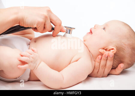 Close-up shot de pédiatre examine trois mois bébé fille. Médecin à l'aide d'un stéthoscope pour écouter de la poitrine du bébé contrôle du rythme cardiaque Banque D'Images