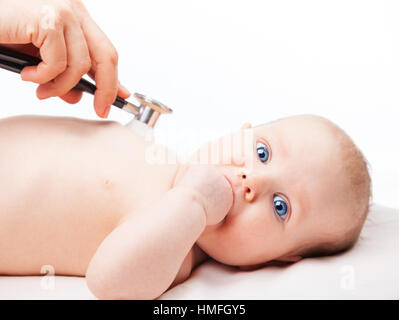 Close-up shot de pédiatre examine trois mois bébé fille. Médecin à l'aide d'un stéthoscope pour écouter de la poitrine du bébé contrôle du rythme cardiaque. Enfant est looki Banque D'Images