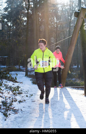OLDENZAAL, Pays-Bas - le 22 janvier 2017 : l'athlète féminine inconnue s'exécute jusqu'à une colline pendant un run dans une forêt Banque D'Images