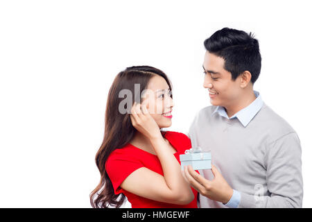 L'homme asiatique rend présent à sa belle dulcinée. Jeune homme donner un cadeau. Cheerful young couple homme et femme à la maison qui offre à chacun d'autres cadeaux fo Banque D'Images