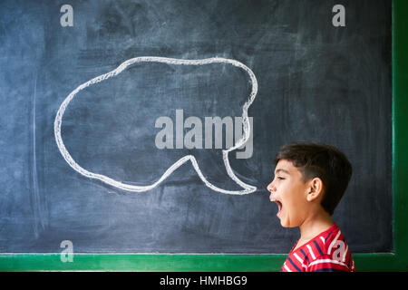 Concept sur tableau noir à l'école. Les jeunes, d'étudiants et d'élèves en classe. Boy crier en classe avec dessin de nuage sur tableau noir. Po Banque D'Images