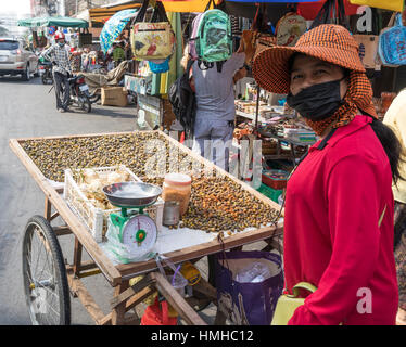 Cockle (vendeur) de moules et panier, marché Russe, Phnom Penh, Cambodge Banque D'Images