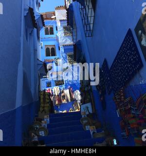 Des marches étroites dans une ruelle de Chechaouen bleu, une ville dans les montagnes du Maroc, près de Tanger. La ligne de l'artisanat des tapis et les escaliers. Banque D'Images