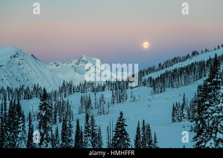 Pleine lune sur l'établissement Canadian Rockies ; vu de l'Esplanada Gamme, chaîne Selkirk ; British Columbia, Canada Banque D'Images