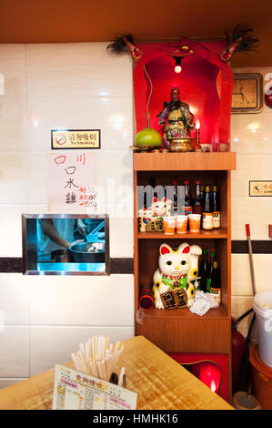 Culte contenant une statue du dieu de la guerre chinois Guan Yu à l'intérieur d'un restaurant de hong kong Banque D'Images