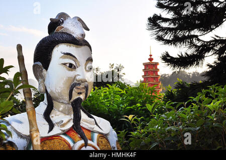 Statue au dix mille bouddhas monastery, hong kong, avec la pagode rouge iconique dans l'arrière-plan. Banque D'Images