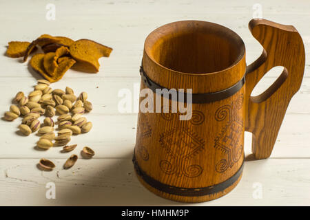 Beer Mug en bois, Pistaches, Pain séché et sur fond de bois Banque D'Images