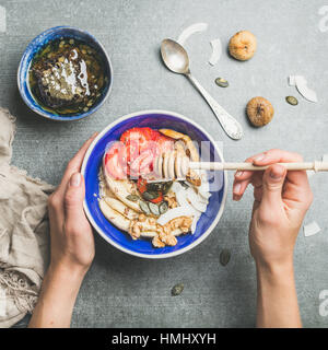 Bol bleu avec petit déjeuner végétarien sain dans woman's hands Banque D'Images