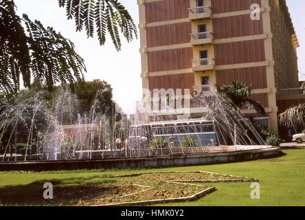 Avis de pulvériser de l'eau des fontaines à l'extérieur de l'entrée à l'hôtel Clarks Shiraz, situé à Agra, Uttar Pradesh, Inde, novembre 1973. Banque D'Images