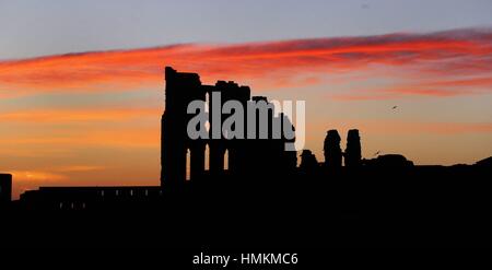 Le soleil se lève sur Tynemouth Priory sur la sur la côte nord-est, comme le week-end des températures devrait s'écrouler comme temps incertain semble prêt à diviser le pays. Banque D'Images