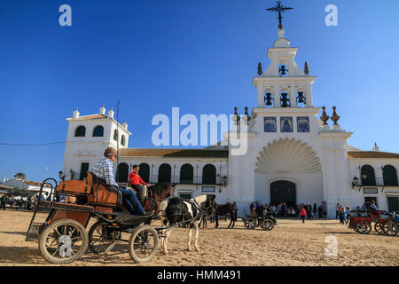 Voitures à cheval et les pèlerins en face de l'Hermitage blancs d'El Rocío / Ermita del Rocío, Almonte, Province de Huelva, Andalousie, Espagne Banque D'Images