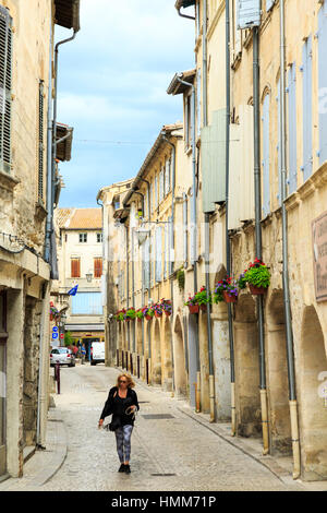 Femme marchant dans la rue étroite voûtée médiévale à Tarascon, Provence, France Banque D'Images