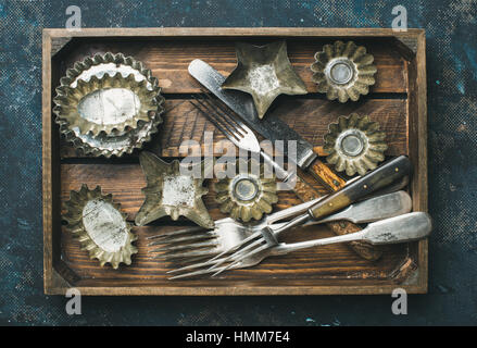 Old vintage tin moules de cuisson et des couverts dans le bac en bois Banque D'Images