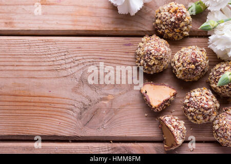 Photo horizontale de quelques petits gâteaux au chocolat avec noix de pistaches et de fleurs Banque D'Images