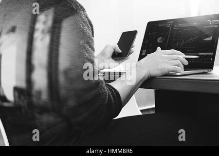 Designer la main à l'aide de paiements mobiles,vente en ligne omni channel,ordinateur portable sur un bureau en bois blanc, noir Banque D'Images