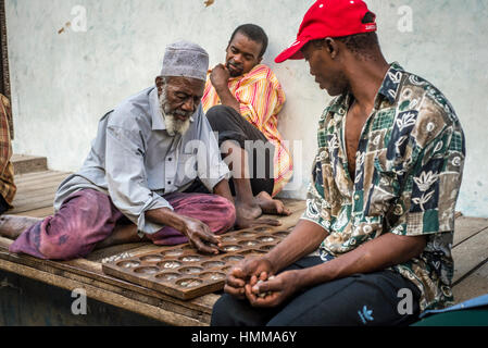 Les hommes joue bao, mancala jeu, sur une rue de Stone Town, Zanzibar, Tanzanie Banque D'Images