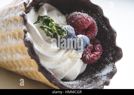 La crème glacée avec berry en cornet de crème glacée. Berry maison cornets de feuilles de menthe et de bleuets frais blanc sur fond de bois, vue du dessus Banque D'Images