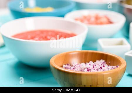 Oignon rouge haché et ingrédients alimentaires sur Turquoise Table de cuisine Banque D'Images